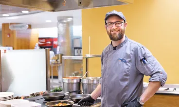 Chef Chris in commercial kitchen cooking in saute pan