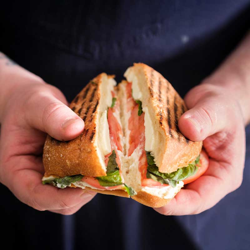 Hands pulling apart a sandwich.