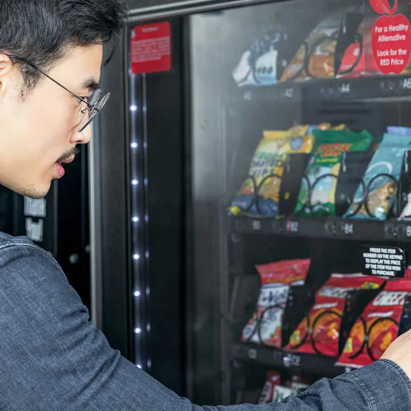 person buying item from vending machine